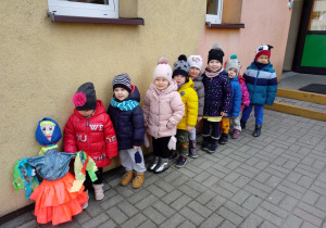 Przedszkolaki idą z Marzanną do ogrodu przedszkolnego